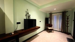 a living room with a flat screen tv on the wall at Abbi Holiday - Jaffna Hotel in Jaffna