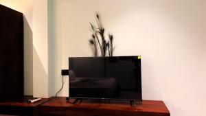 a flat screen tv sitting on top of a wooden table at Abbi Holiday - Jaffna Hotel in Jaffna