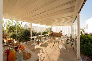 an outdoor patio with tables and chairs and windows at Borgo Tufaia in Fasano