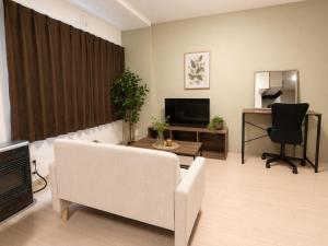 a living room with a white couch and a television at Rent菊水 -FIX HOME- in Sapporo