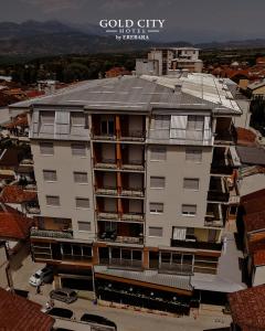a large white building with a gray roof at Gold City Hotel by Erebara in Debar
