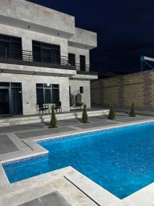 a swimming pool in front of a building at Mughni home in Ashtarak