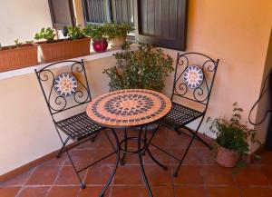 a table and chairs on a patio with plants at Villa Elsa, Cesena zona Ippodromo in Cesena
