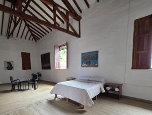 a bedroom with a bed and a table in a room at Republicano Hostal in Jericó