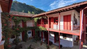 an apartment building with red balconies and plants at Republicano Hostal in Jericó