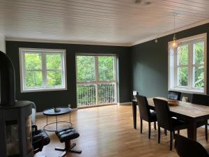 a dining room with a table and chairs and windows at Spacious Apartment - Central Voss - Free Parking in Vossevangen
