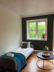 a bedroom with a bed and a table and a window at Spacious Apartment - Central Voss - Free Parking in Vossevangen