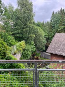 a fence in front of a yard with a tree at Spacious Apartment - Central Voss - Free Parking in Vossevangen