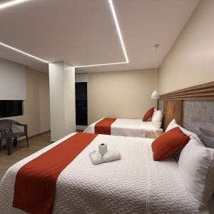 a hotel room with two beds and a tv at Hotel Ulloa Inn in Quito