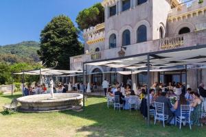 a group of people sitting in chairs in front of a building at Villa Borgo Musolino in Messina
