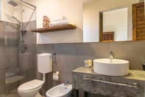 a bathroom with a sink and a toilet and a mirror at Villa Borgo Musolino in Messina
