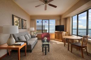 a living room with a couch and a tv at The Hotel Captain Cook in Anchorage