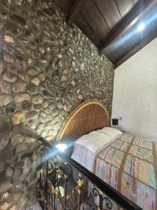 a bedroom with a stone wall with a bed at Quinta Luz de Luna in Jusnajal