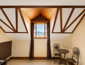 ein Zimmer mit Tisch und Stühlen und einem Fenster in der Unterkunft Hotel Willisau in Teresópolis