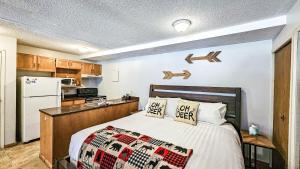 a bedroom with a bed and a kitchen at Horsethief Lodge by StayIn in Panorama