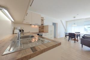 a kitchen with a sink and a table in a room at Residenz Seestern Wohnung 32 in Boltenhagen