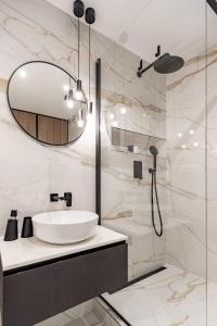 a bathroom with a sink and a shower with a mirror at MCK Apartments in Košice +12 photos