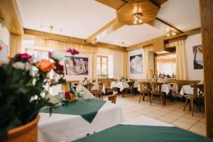 a dining room with tables and chairs and flowers at Der Bodenbauer in Thörl