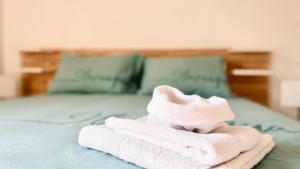 a pile of towels sitting on top of a bed at BorgoLuce Spacious Apt - FREE Parking - Near Airport & Center in Bergamo