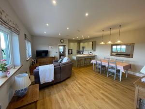 a living room and kitchen with a couch and a table at The Hayloft in Calne