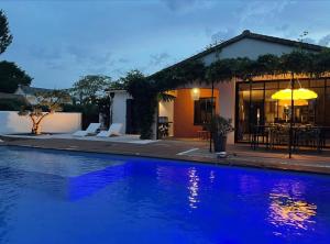 a villa with a swimming pool in front of a house at Home Paradis & Spa in Souvigné