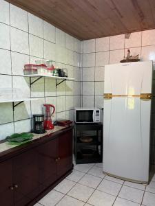 a kitchen with a white refrigerator and a microwave at Refúgio Mundo dos Pássaros in Sao Jorge +27 photos