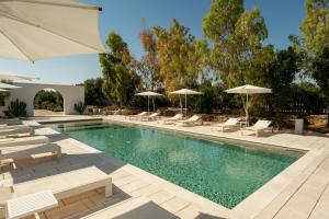a swimming pool with lounge chairs and umbrellas at Borgo Tufaia in Fasano