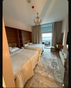 a hotel room with two beds and a chandelier at Studio Alamein towers in El Alamein