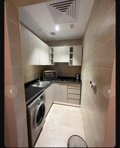 a small kitchen with a washing machine in it at Studio Alamein towers in El Alamein