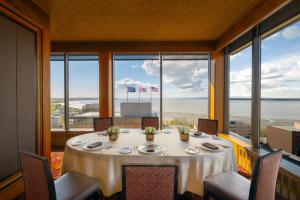 a dining room with a table and views of the ocean at The Hotel Captain Cook in Anchorage