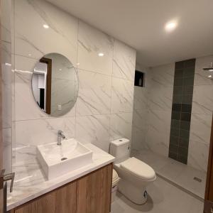 a bathroom with a sink and a toilet and a mirror at Hotel Ulloa Inn in Quito +5 photos
