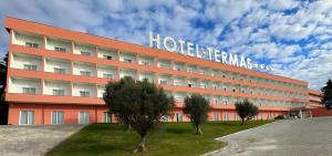 a large red building with a sign on it at Palace Hotel & SPA Termas do Bicanho in Soure