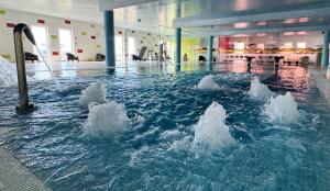 a large pool of water in a building at Palace Hotel & SPA Termas do Bicanho in Soure