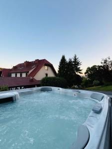 a hot tub in a yard with a house at Hotel Kasztelan in Dobczyce