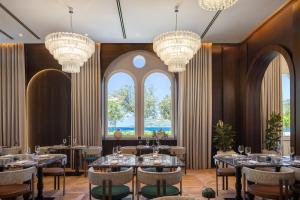 a dining room with tables and chandeliers at Aminess Younique Korcula Heritage Hotel in Korčula