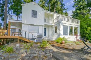 a white house with a deck and a balcony at Charming Waterfront Home with Mt Rainier View in Olympia