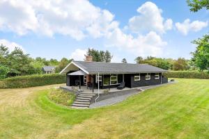 a black house with a large yard in front of it at LF16127-Logstor-Amandasvej-27 in Trend