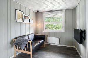 a living room with a leather couch and a television at LF16127-Logstor-Amandasvej-27 in Trend