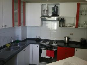 a kitchen with a sink and a stove top oven at Vista Laguna in San Pedro de la Paz