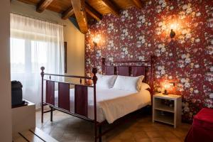 a bedroom with a bed with a floral wall at Casale Verdeluna Wine Resort in Piglio +59 photos