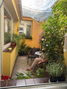 a couple of people sitting on a porch with plants at Apartament Toruń Starówka - Ducha in Toruń