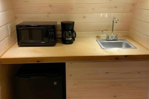 a kitchen counter with a microwave and a sink at Sun Outdoors Yellowstone North in Gardiner +11 photos
