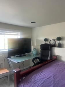 a bedroom with a desk with a chair and a tv at water front 2 bedroom suite in Victoria