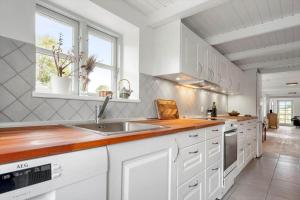 a kitchen with white cabinets and a sink at 3309-Stege-Holmemosevej-9 in Stege