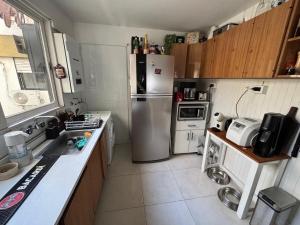 a small kitchen with a stainless steel refrigerator at my depto in Vicente López +2 photos