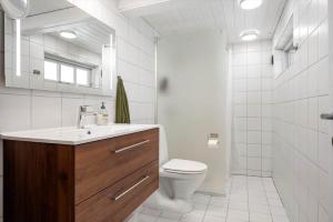 a white bathroom with a toilet and a sink at 3309-Stege-Holmemosevej-9 in Stege +14 photos