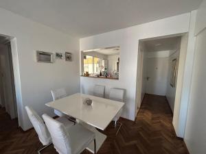 a white dining room with a white table and white chairs at my depto in Vicente López