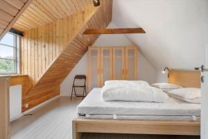 a bedroom with a bed with a wooden headboard at 3309-Stege-Holmemosevej-9 in Stege