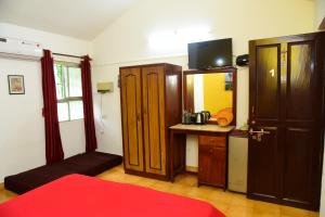 a room with a desk and a cabinet with a mirror at Jes Guest House in Majorda +42 photos