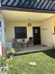 a patio with two chairs and a table on a house at Casa à Beira Mar em Praia Seca Araruama RJ in Araruama